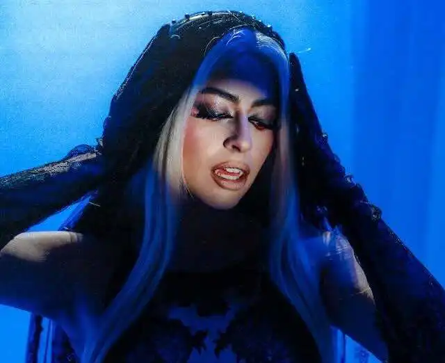 Stunning dark fantasy model with vibrant blue hair and dramatic makeup for LGBTQ+ and fashion enthusiasts.