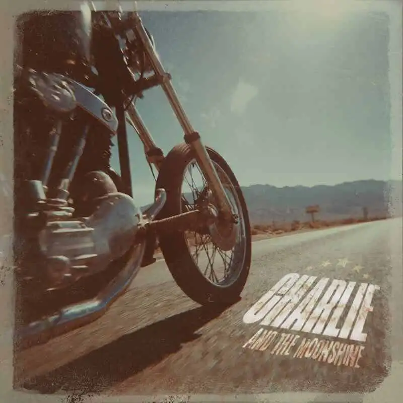 Motorcycle riding on open road in desert landscape.