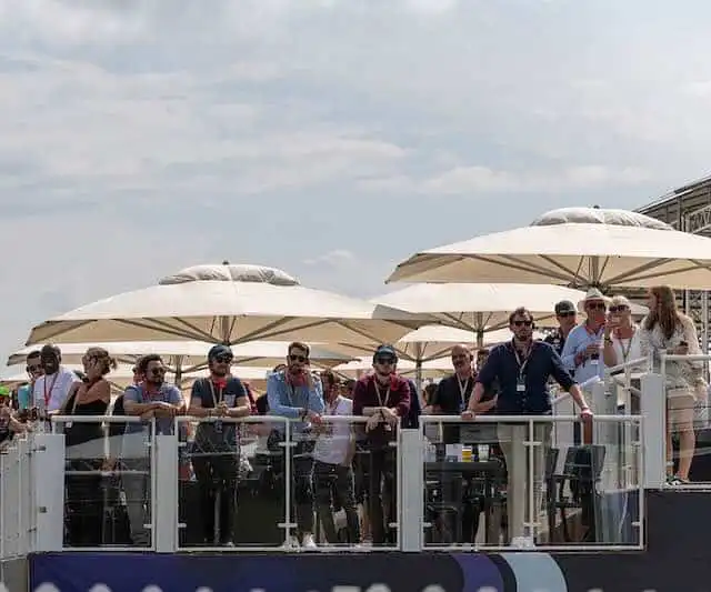 Outdoor event with people under umbrellas.