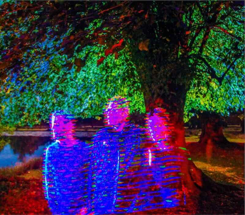 Colorful illuminated trees and reflections on water.