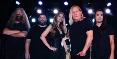 SIREN Rediscover Their Spark on New Melodic Rock Record Alt text: A diverse heavy metal band performing on stage with dramatic lighting and energetic presence.