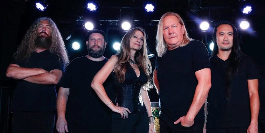 Alt text: A diverse heavy metal band performing on stage with dramatic lighting and energetic presence.