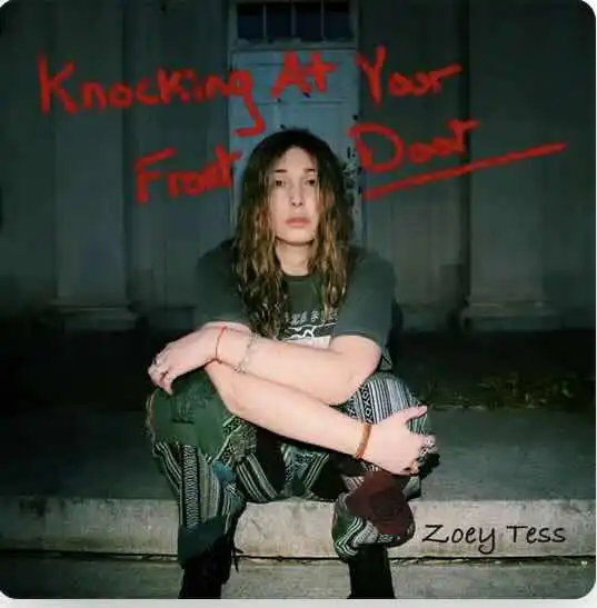 Young woman sitting on curb at night.