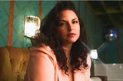 Americana singer-songwriter Danni Nicholls in a peach blazer against teal wallpaper, Nashville 2026.