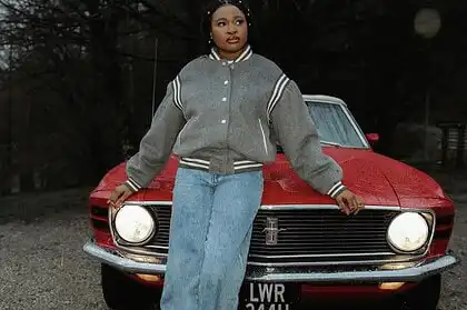 Brenique Adams standing in front of a vintage red car, promoting her Oasis EP and new single "Light.