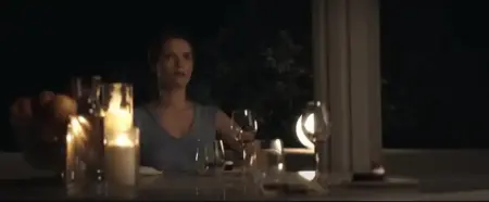 Elegant woman enjoying wine tasting at night with candles and glasses.