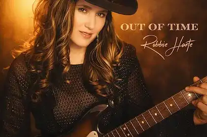 Robbie Harte in cowboy hat holding guitar for country music promotion.