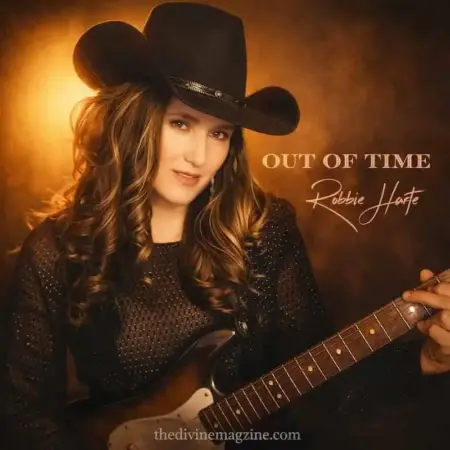 Robbie Harte in cowboy hat holding guitar for country music promotion.