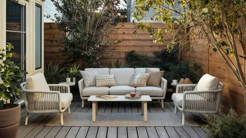 Outdoor patio furniture set with comfortable sofas and chairs in a cozy backyard setting - Divine Magazine.