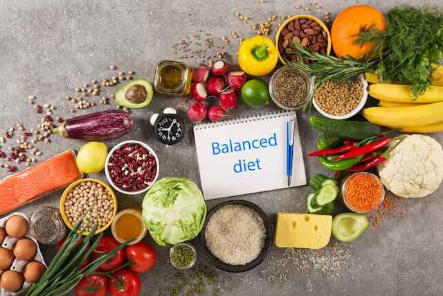 Healthy foods like vegetables, fruits, and grains on a table.