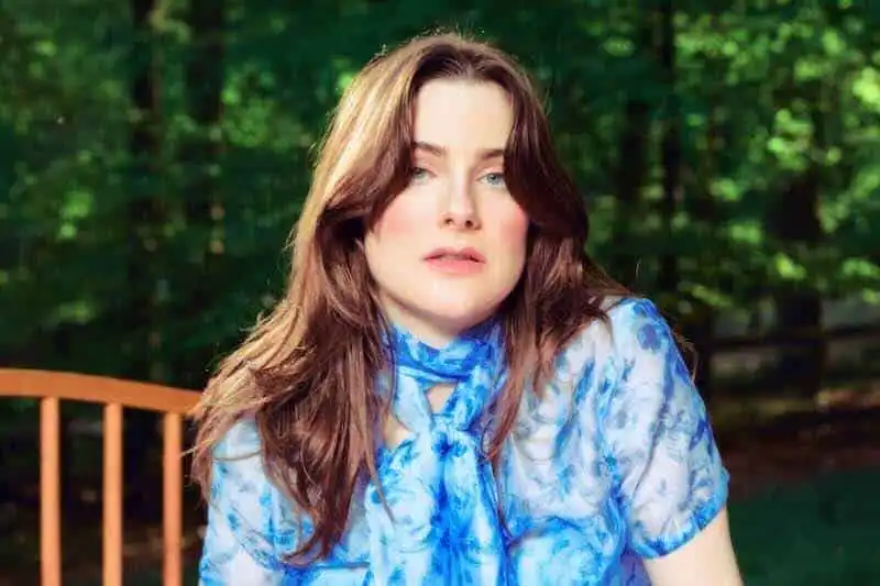 Beautiful woman in nature wearing a blue patterned blouse.