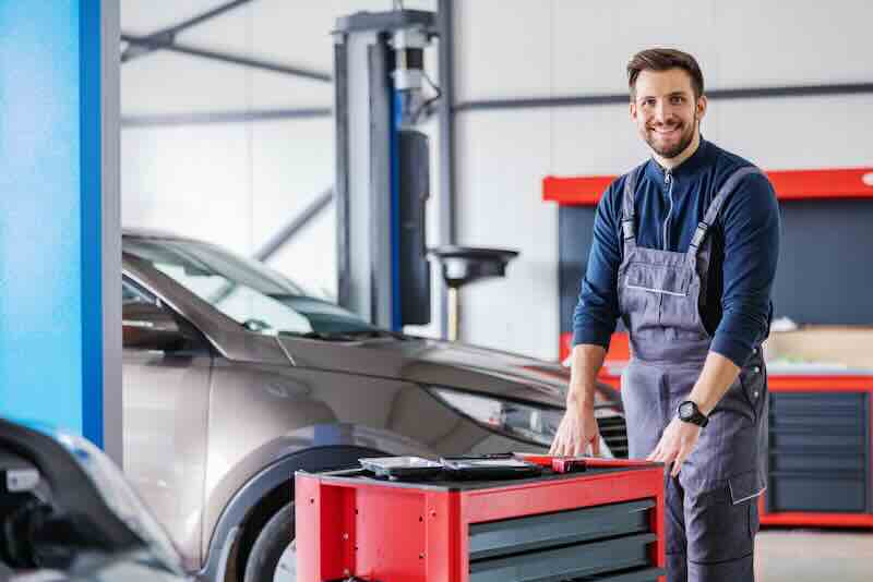 Automotive technician working in a car repair shop.