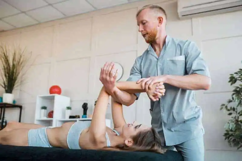 Physiotherapist assisting physical therapy session.