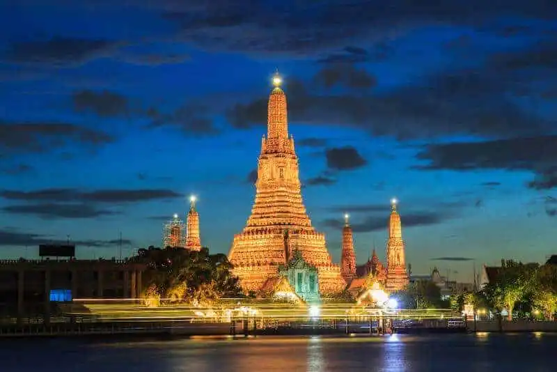 Stunning nighttime view of historic temples illuminated in Bangkok, Thailand, showcasing culture and architecture.